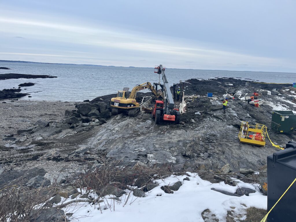 Excavators taking apart the shipwreck for site cleanup
